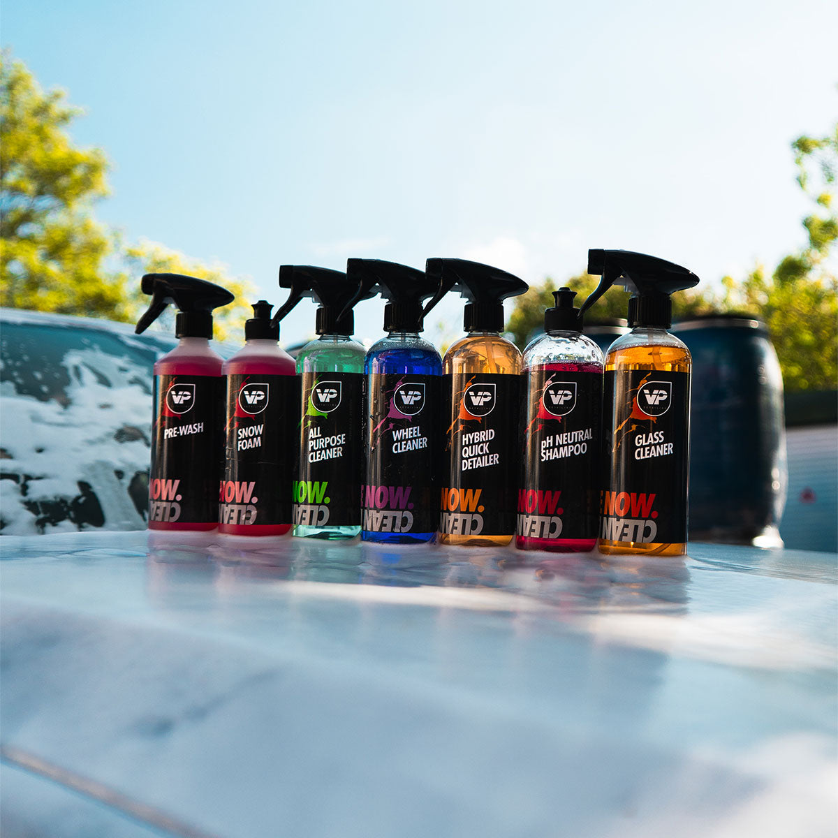 7 bottles of vp detailing car cleaning products on top of snow foamed car