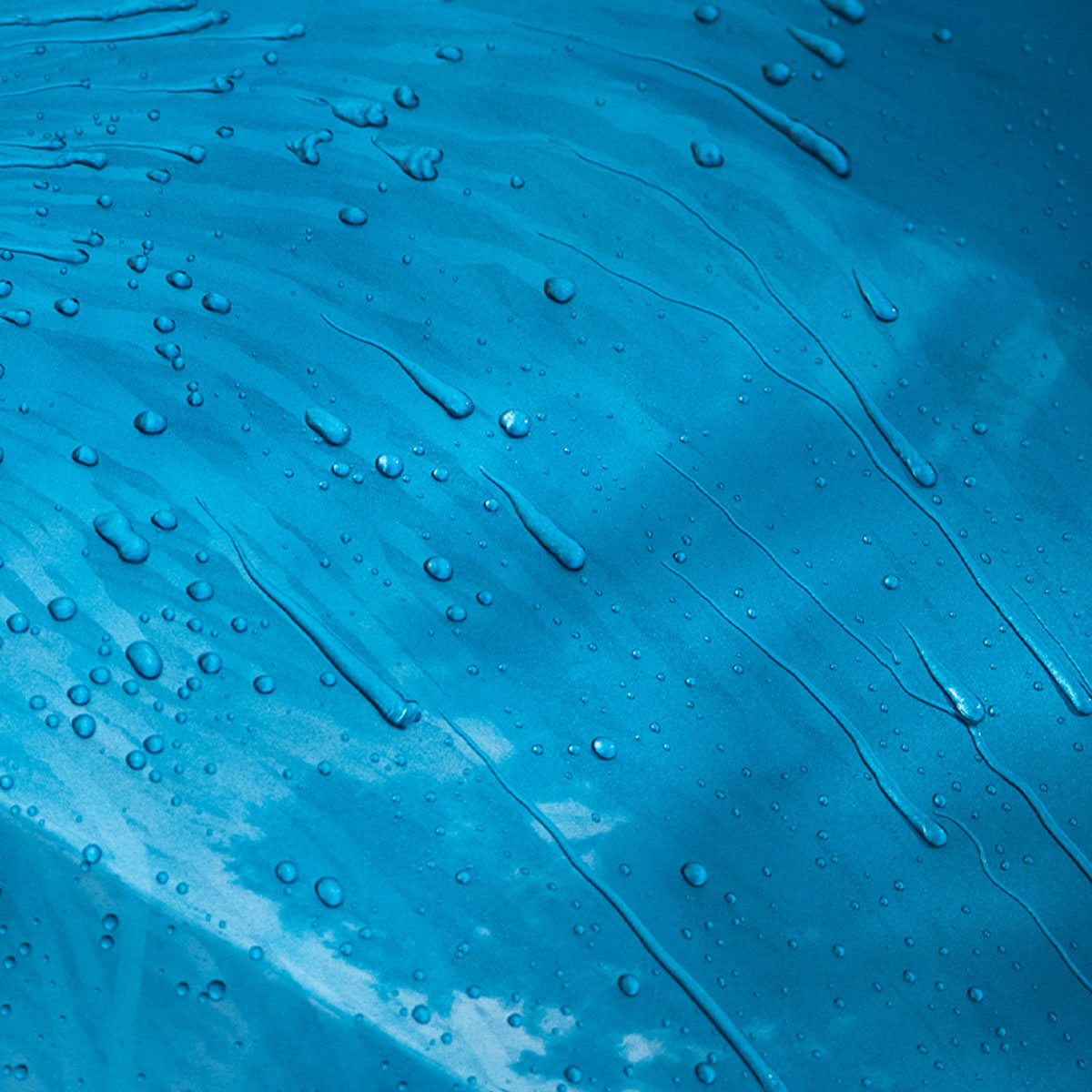 close up of water beading on blue car