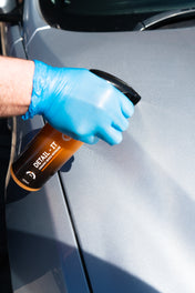 ceramic orange quick detailer being sprayed onto car