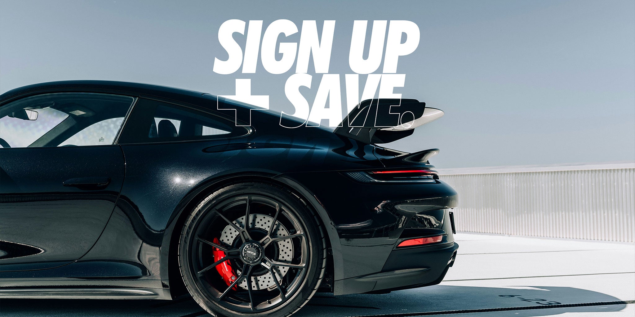 Rear end of Porsche gt with wing and black wheels