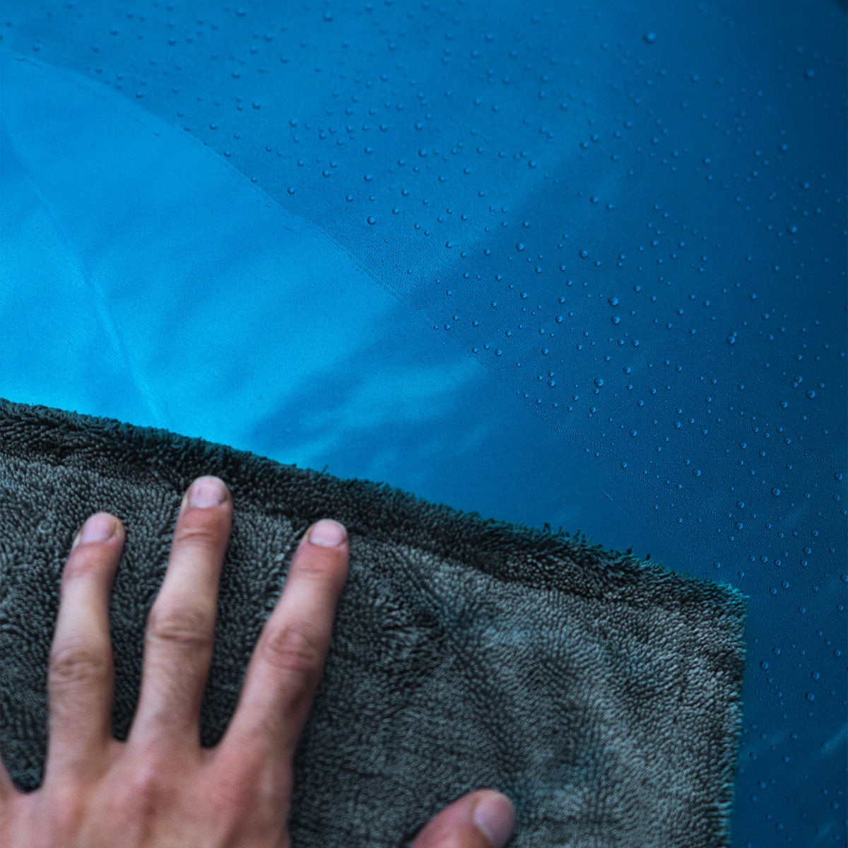 drying towel being using on wet blue bmw