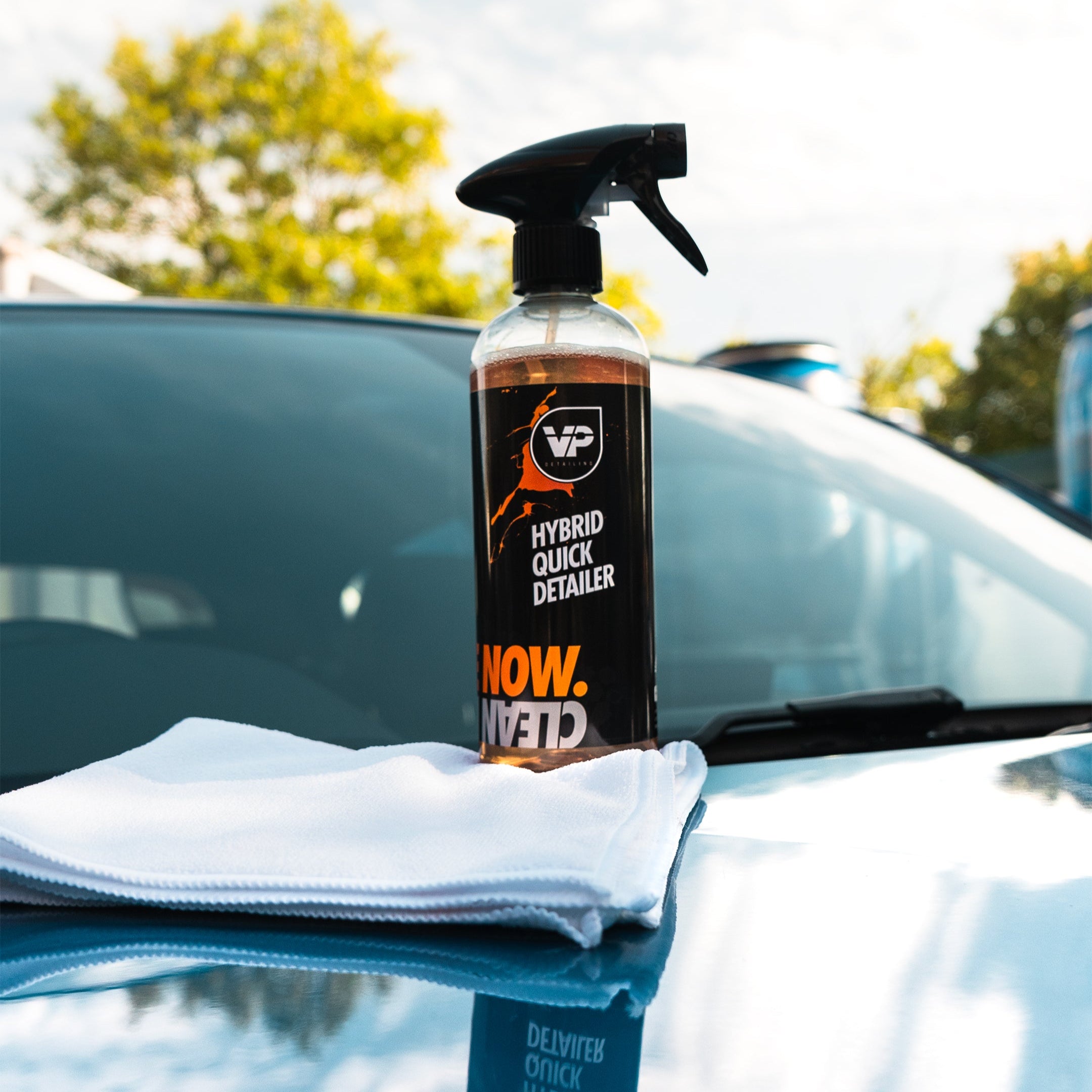 vp detailing hybrid quick detailer sat on top of a white microfibre positioned on hood of shiny car