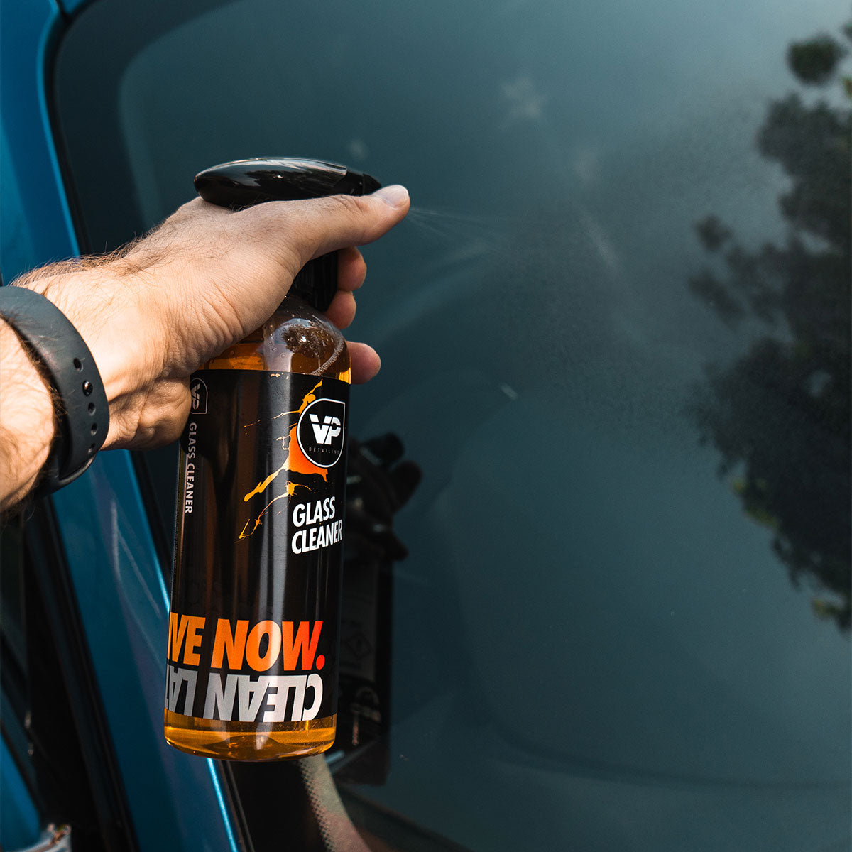 vp detailing glass cleaner held in hand being applied to car glass