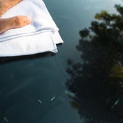 white microfibre cloth cleaning glass windscreen with vp detailing glass cleaner