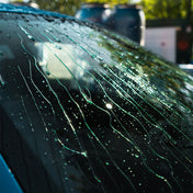 Glass with water beading and running off windscreen