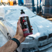 vp detailing snow foam held up in front of car being cleaned and detailed by it