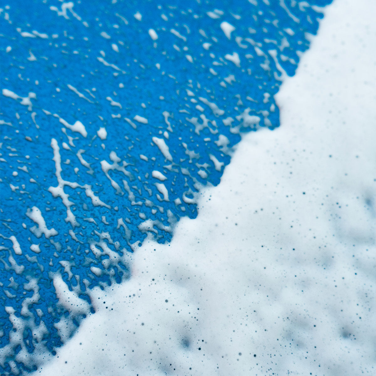 vp detailing's snow foam sprayed over blue car bonnet showing half and half
